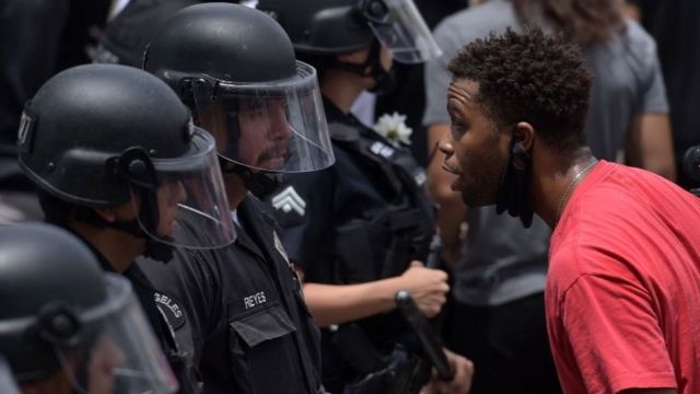 A protester speaks with an LAPD officer during a demonstration over the death of George Floyd in Hollywood, California on June 2, 2020. (AFP)