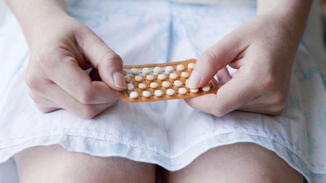 Una mujer toma pastillas anticonceptivas