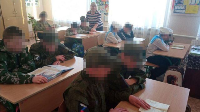 Ukrainian children wearing Russia military uniforms