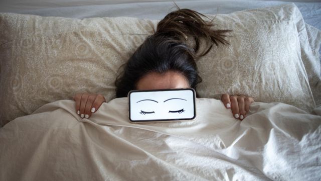 mulher dorme com celular na frente