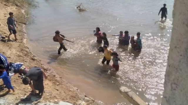 ผู้ลี้ภัยการสู้รบหนีข้ามแม่น้ำ