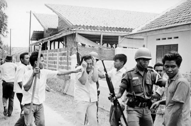 Seorang mahasiswa keturunan Cina melindungi mukanya saat dicemooh dan diserang secara fisik oleh sejumlah pemuda yang menyerang Universitas Res Publika, pada 15 Oktober 1965.. 