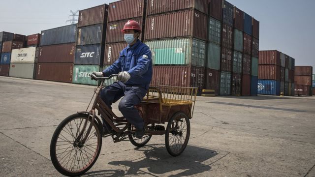 Рабочий на велосипеде в уханьском речном порту