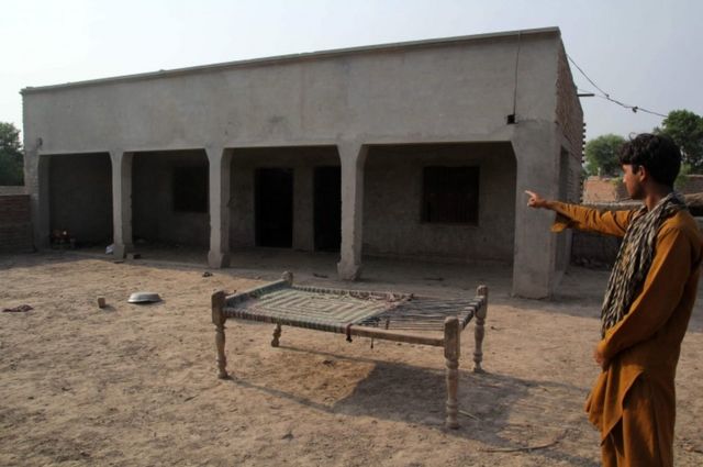 Pakistan'ın Muzaffarabad kasabasında bir kişi gazetecilere ilk tecavüz suçunun işlendiği evi gösteriyor