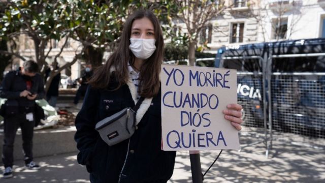 Jovem segura cartaz de protesto na espanha