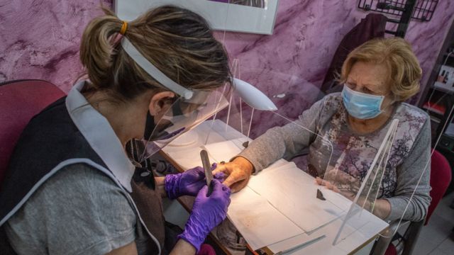 Una manicurista arregla las manos de una clienta en Barcelona.
