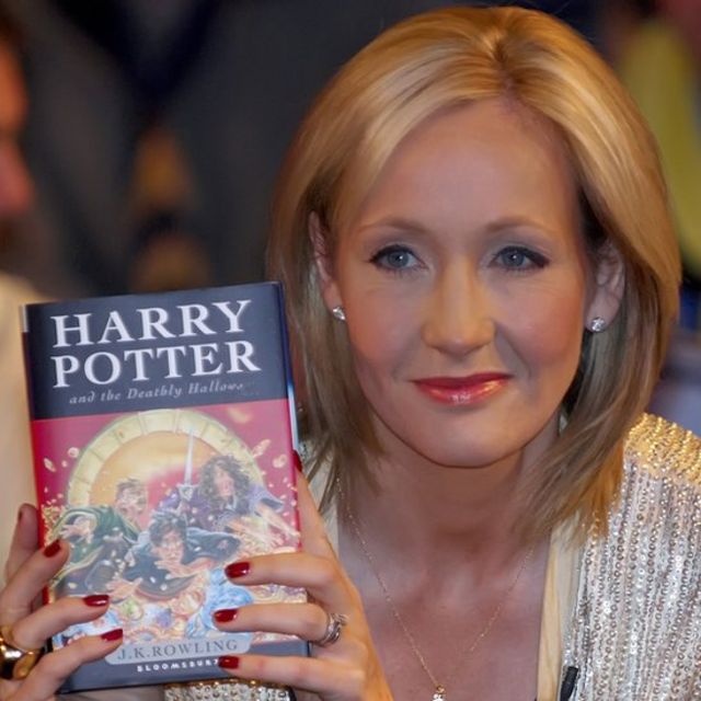 JK Rowling holding a copy of Harry Potter