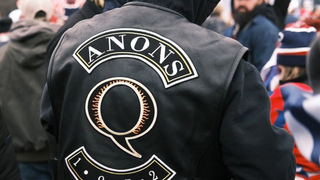 Person photographed from behind wearing a QAnon jacket