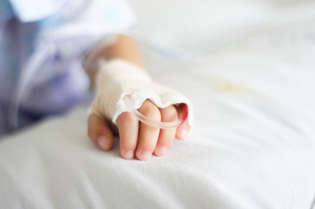 Mão de criança com soro intravenoso