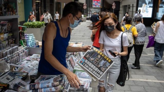 香港某报摊前一位年轻女性在购买《苹果日报》（18/6/2011）