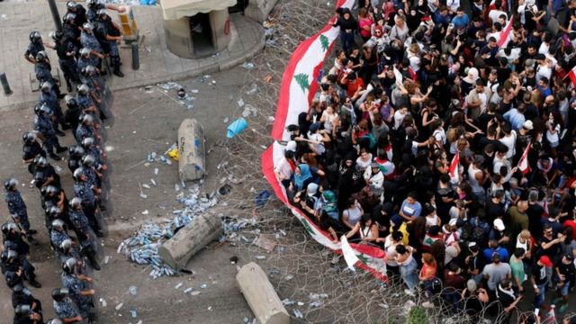 قوات من الشرطة اللبنانية والمتظاهرين تفصل بينهم أسلاك شائكة في بيروت.