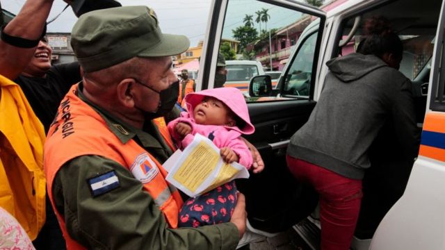 Un guardia civil carga a un niño en Blufields, Nicaragua