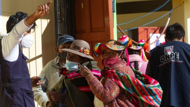 Indígenas peruanos reciben indicaciones en un centro de votación.