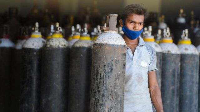 Um trabalhador providencia cilindros médicos de oxigênio para transportar para hospitais nos arredores de Hyderabad em 23 de abril de 2021.