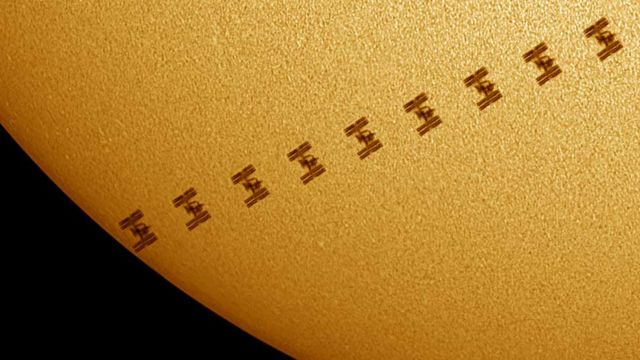 A silhueta da Estação Espacial Internacional contra o Sol