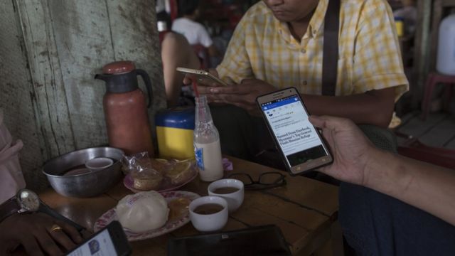 People look at Facebook on their phones at a teashop in Yangon, Myanmar, in August 2018