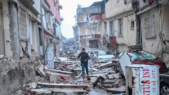 Un hombre camina por una calle llena de escombros en Hatay