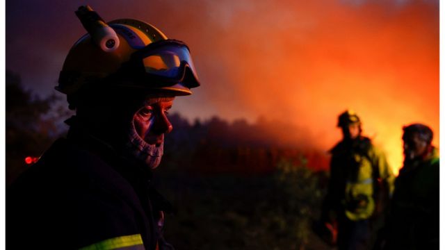 Un grupo de bomberos frente a un incendio