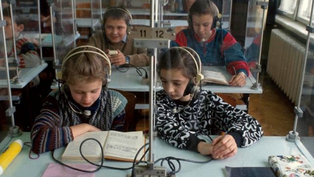 Crianças com fones de ouvido em sala de aula