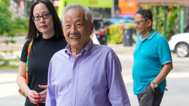 Presidential candidate Ng Kok Song (C) arrives at a polling station to cast his vote in Singapore