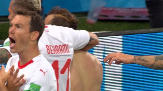 Switzerland captain Stephan Lichtsteiner makes the 'double-headed eagle' gestured to celebrate Xherdan Shaqiri's goal against Serbia