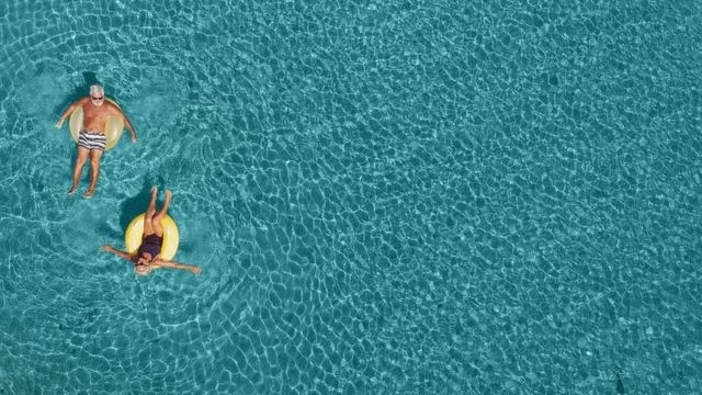 Una pareja adulta flotando en una piscina