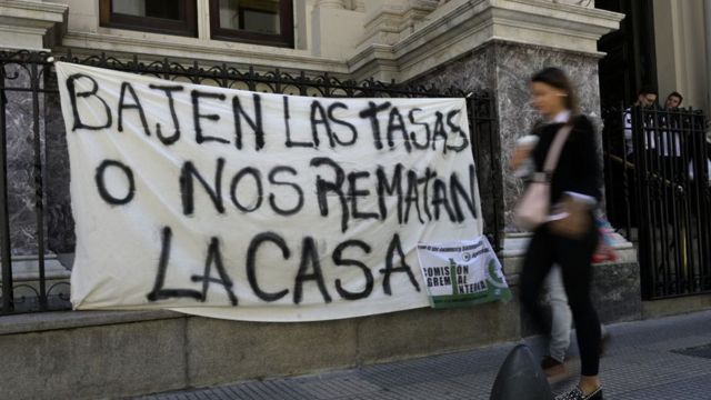 "Bajen las tasas o nos ramatan la casa" reza un cartel colgado en las rejas del Banco Central de Argentina