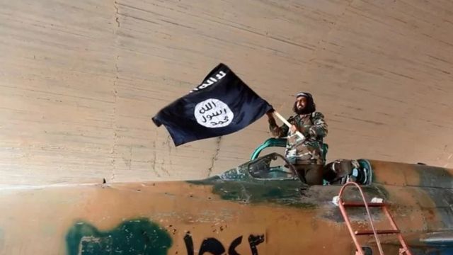 مقاتل يرفع تنظيم ما يعرف بالدولة الإسلامية