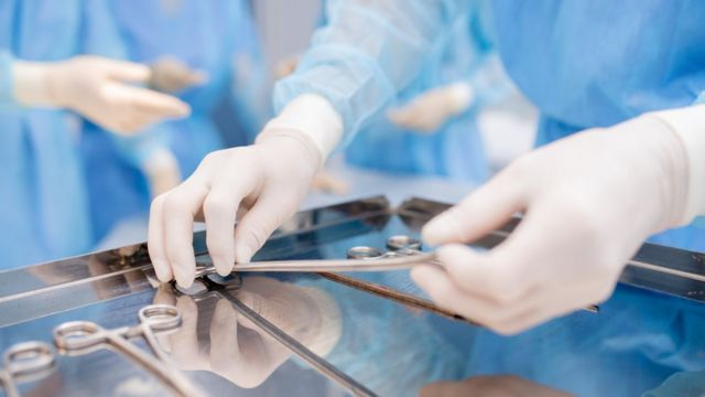 Gloved hands arrange medical instruments