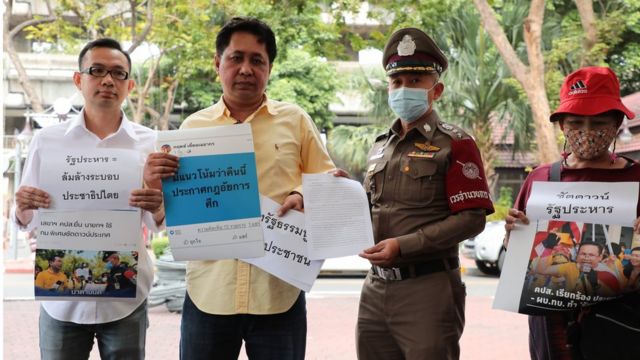 คนยืนถือป้ายประท้วง