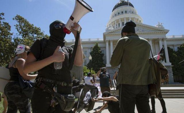 Los manifestantes trataron de incendiar una bandera en las afueras del capitolio en Sacramento.