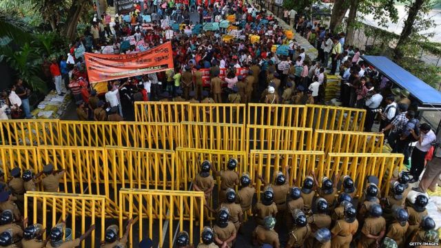 Sri Lankan police form a blockade on a road leading to President Mahinda Rajapakses office during a demonstration held by the opposition Peoples Liberation Front party (JVP) in Colombo on December 11, 2013. The JVP is protesting high living costs and demanding higher government spending on education. AFP PHOTO/ Ishara S.KODIKARA (Photo credit should read Ishara S.KODIKARA/AFP via Getty Images)