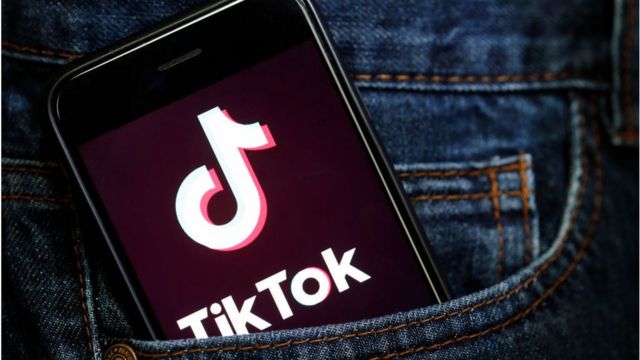 TikTok app on a smartphone sticking out of a pocket