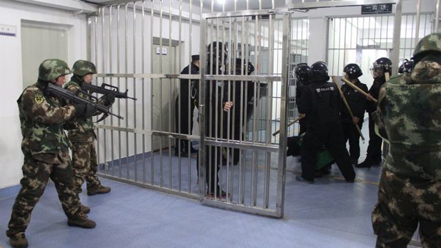 Um detido é rodeado por policiais armados