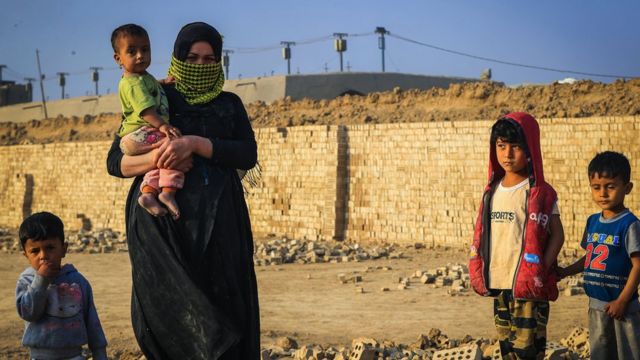 امرأة عاملة تغطي وجهها لحماية نفسها من الغبار وأشعة الشمس في بغداد في 7 مارس/ آذار 2023