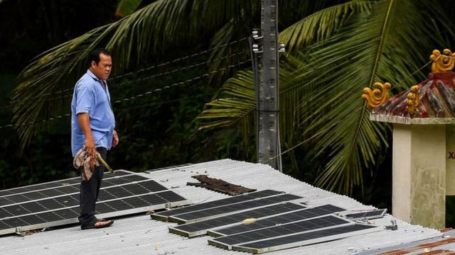 Việt Nam vẫn đang loay hoay để thoát khỏi năng lượng 'bẩn' - than. Ảnh chụp một người dân với các tấm pin mặt trời trên nóc nhà ông ở An Giang, tháng 9/2022