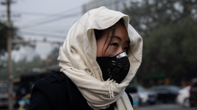 Mujer con una máscara para protegerse de la contaminación en Pekín