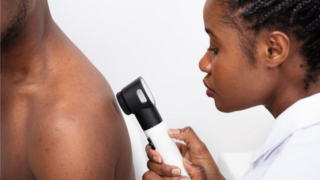 Woman examining a black man's body