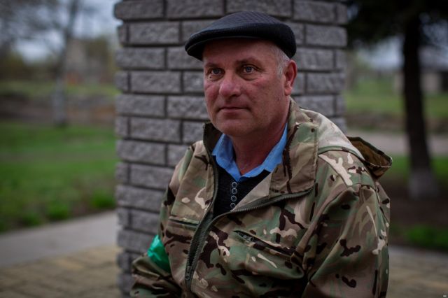 Валерій Дугельний, голова сільради, сидить біля пам'ятника Тарасу Шевченку