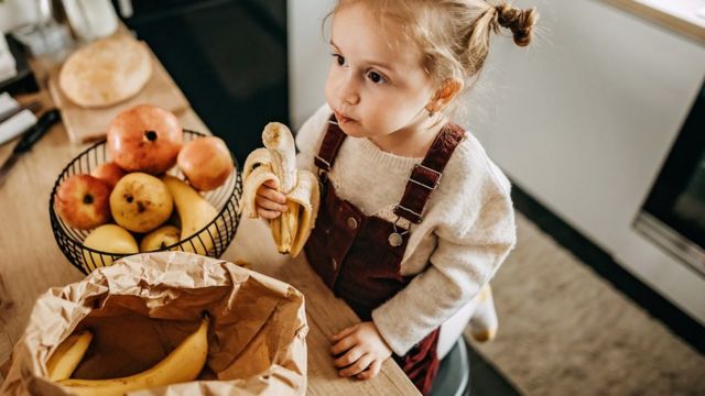 Little girl eating a banana