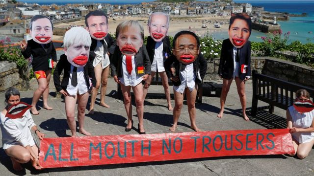英国康沃尔郡圣艾夫镇一群示威者扮演与会各国领导人并拉开“光张嘴吧不穿裤子”标语（13/6/2021）
