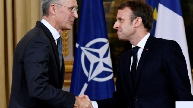 الرئيس الفرنسي ماكرون يصافح أمين عام حلف الناتو ينس ستولتينبيرج