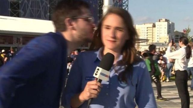 A TV reporter is kissed while reporting live on air