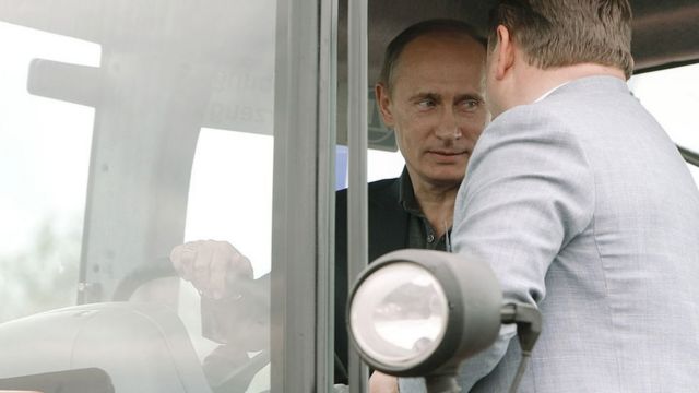 بوتين يجلس وراء عجلة القيادة في جرار زراعي خلال زيارة له إلى مدينة تمبوف الروسية في 2010
