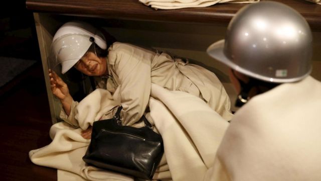 A woman takes shelter after another earthquake hit the area at a hotel in Kumamoto, southern Japan, 16 April 2016.