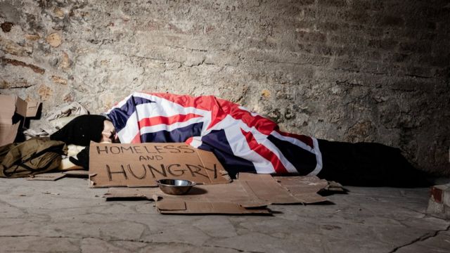 رجل بلا مأوى ينام في الشارع مغطى بعلم بريطانيا العظمى