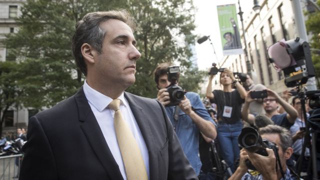 Michael Cohen leaves court looking solemn, surrounded by photographers, 21 August 2018