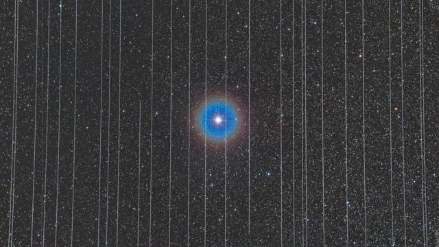 Los rastros de luz de satélites en movimiento componen esta fotografía de una estrella.