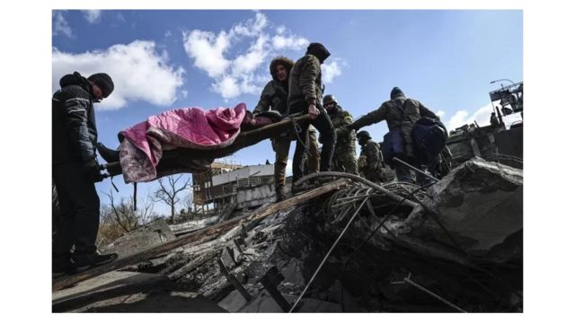 Soldados carregam maca com pessoa ferida após ataque russo na Ucrânia