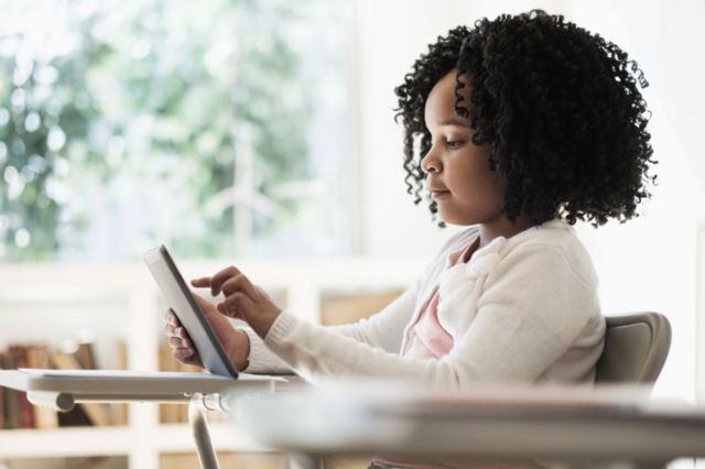 Niña escribiendo en una tableta